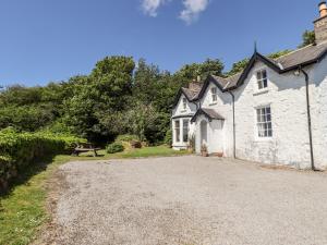 an old white house with a gravel driveway at Port Donnel Cottage in Dalbeattie