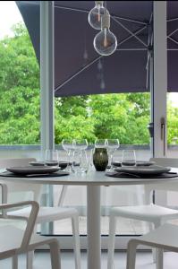 a white dining table with wine glasses on it at seelandsuite Bodensee in Bermatingen