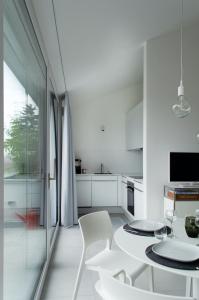 - une cuisine blanche avec une table et des chaises blanches dans l'établissement seelandsuite Bodensee, à Bermatingen