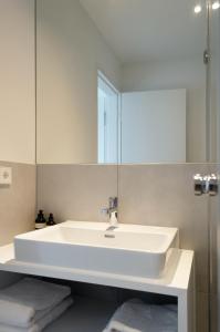 a bathroom with a white sink and a mirror at seelandsuite Bodensee in Bermatingen