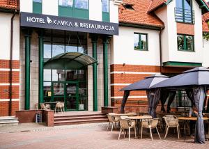 restauracja ze stołami i parasolami przed budynkiem w obiekcie Hotel KAVKA & Restauracja w mieście Czersk Pomorski
