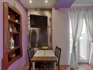ein Esszimmer mit einem Tisch und einem TV an der Wand in der Unterkunft Beauty of Krakow Studio in Krakau