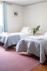 um quarto com duas camas e um vaso de flores em Karkausmäen Kammari em Kinnula