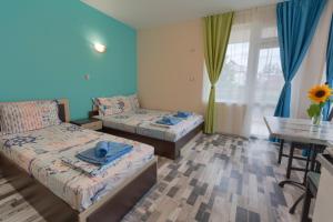キテンにあるKazlarov Guest Houseのベッドルーム1室(ベッド2台、テーブル、窓付)