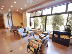 een wachtkamer met stoelen en tafels en een groot raam bij Hotel Route-Inn Nagaizumi Numazu Inter 2 in Nagaizumi