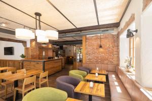 um restaurante com mesas e cadeiras de madeira e uma parede de tijolos em JOESEPP´S HOTEL am Hallhof em Memmingen