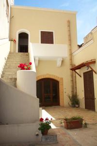 a house with stairs and red flowers on it at Papparina House in Marsala