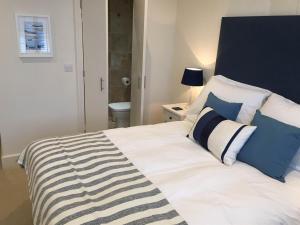a bedroom with a white bed with blue and white pillows at The George Inn in Braunton