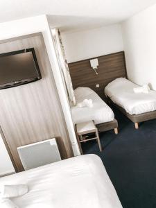 ヴァランスにあるThe Originals City, Hôtel Valence Estのベッド2台とテレビが備わる小さな客室です。