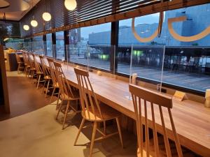 una larga mesa de madera y sillas en un restaurante en HOTEL GLOBAL VIEW Niigata, en Niigata