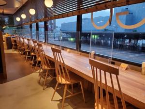 HOTEL GLOBAL VIEW Niigata في نيغاتا: طاولة وكراسي خشبية طويلة في مطعم