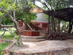 a house with a pile of logs in front of it at Wilgeboomsdrift Safaris in Modimolle