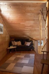 a living room with a couch in the attic at Holz Chalet Nähe Salzburg in Feldbach