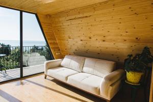 a living room with a white couch and a large window at Sunland-სანლენდი in Buknari