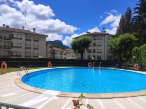 a large blue swimming pool in front of some buildings at Apartamento Alba in Jaca