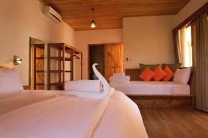 a bedroom with two beds with white sheets at Akasha Beach Club in Bulukumba