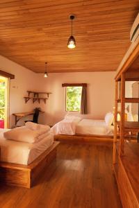 a bedroom with two beds and a wooden ceiling at Akasha Beach Club in Bulukumba