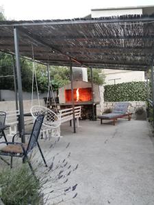 a patio with a fire pit and chairs and a swing at Apartments Valentino in Gradac