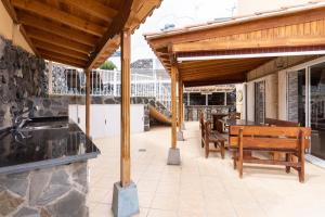 a patio with a wooden pavilion with a table and benches at Home2Book Metro Tenerife Adeje, Private Pool in Adeje