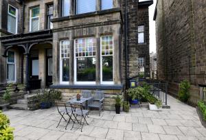 a patio with chairs and a table in front of a building at Harrogate Self Catering - Mews Suite - Garden in Harrogate
