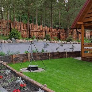 a garden with a swing in the grass at LisieBagno in Miłomłyn