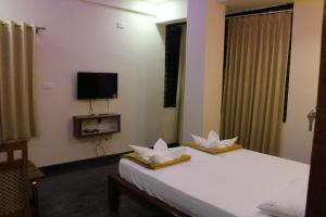 カナーカプラにあるGolden pride hotel ( the pride family restaurant)のベッドルーム1室(白い花2本のベッド1台付) +21枚の写真