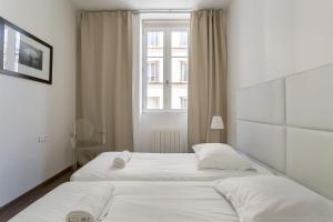 two beds in a white room with a window at LE JACQUARD Garage Lyon Centre pour 2 à 8 pers in Lyon
