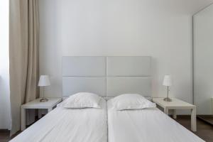 - une chambre blanche avec 2 lits et 2 lampes dans l'établissement LE JACQUARD Garage Lyon Centre pour 2 à 8 pers, à Lyon