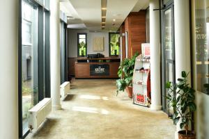 un couloir de bureau avec des plantes en pot et un bureau dans l'établissement Heritage Hotel Krone, à Sarajevo