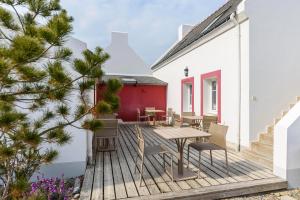 a wooden deck with a table and chairs at Hotel Le Clos Fleuri in Le Palais