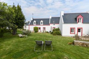 a house with two chairs in the yard at Hotel Le Clos Fleuri in Le Palais