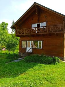 Cette maison en bois dispose d'un balcon. dans l'établissement Приватна Садиба Потічок, à Slavsko
