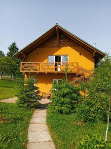 a yellow house with a porch and a pathway leading to it at Приватна Садиба Потічок in Slavske