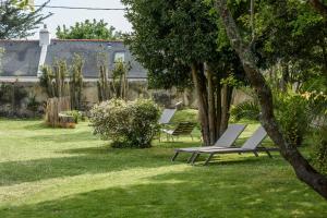 a group of lounge chairs sitting in a yard at Hotel Le Clos Fleuri in Le Palais