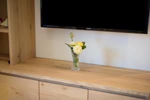 un vaso con fiori gialli seduto sopra una tv di Teutenhofer Kirsche a Velturno