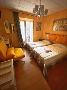 Un dormitorio con dos camas y una silla y una ventana. en Boutique Hotel Couleurs Suds, en Cannes