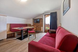 - un salon avec un canapé rouge et une table dans l'établissement Residence Condor Apt Gitschberg, à Maranza