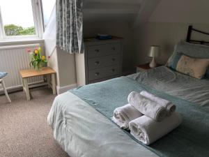 a bedroom with a bed with towels on it at Borthalan House in Carbis Bay