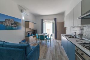 cocina y sala de estar con sofá y mesa en Appartamento Blu, en Dorgali