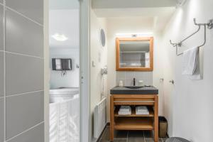 a small bathroom with a sink and a mirror at Hotel Le Clos Fleuri in Le Palais