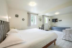 a bedroom with a large white bed and a couch at Hotel Le Clos Fleuri in Le Palais