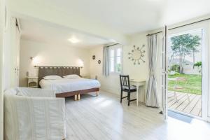 a bedroom with a bed and a desk with a chair at Hotel Le Clos Fleuri in Le Palais