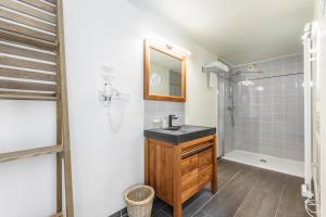 a bathroom with a sink and a shower at Hotel Le Clos Fleuri in Le Palais