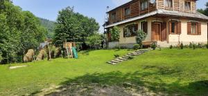 een groot huis met een tuin ervoor bij Arnika Tatariv in Tatariv