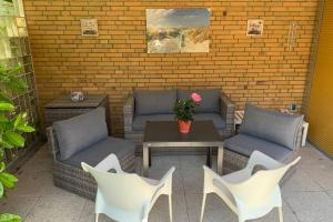 um pátio com sofás, uma mesa e cadeiras em Near „Hamburg summer lounge“ cozy sunny green em Quickborn