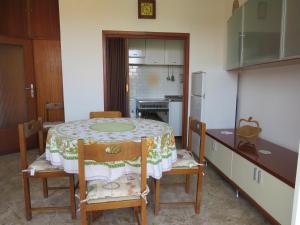 a kitchen with a table and chairs and a kitchen with a refrigerator at La Baia di Lori in Pesaro