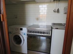 a kitchen with a stove and a washing machine at La Baia di Lori in Pesaro