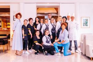 a group of people posing for a picture in a room at Albergo Sorriso in Boario Terme