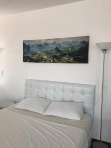 a bedroom with a white bed with a picture on the wall at Villa Residence in Sînmartin