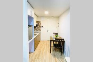 a kitchen and dining room with a table and chairs at Cozy Studio Type Condo with Pool in Biñan